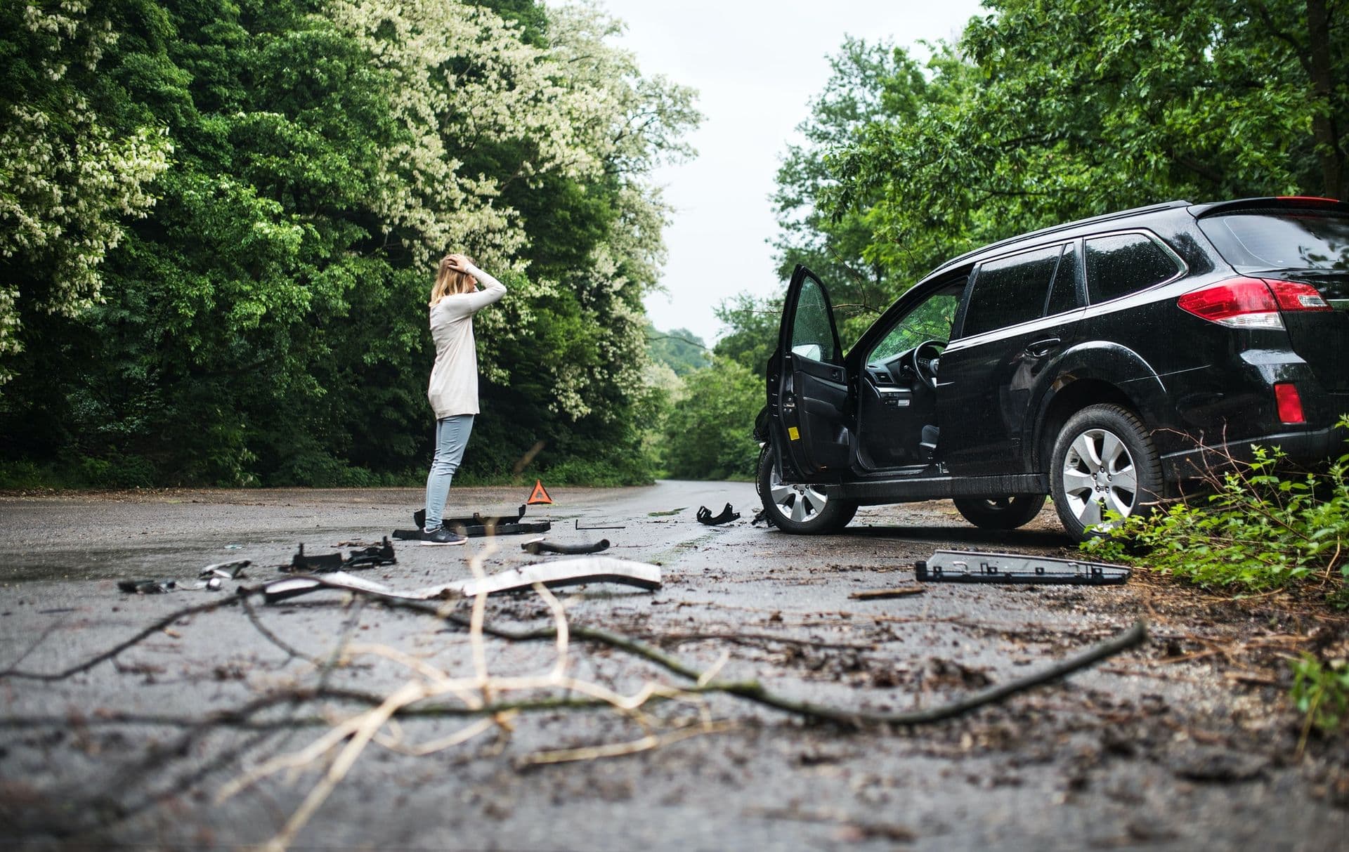 young-woman-standing-by-the-damaged-car-after-a-car-accident-.jpg